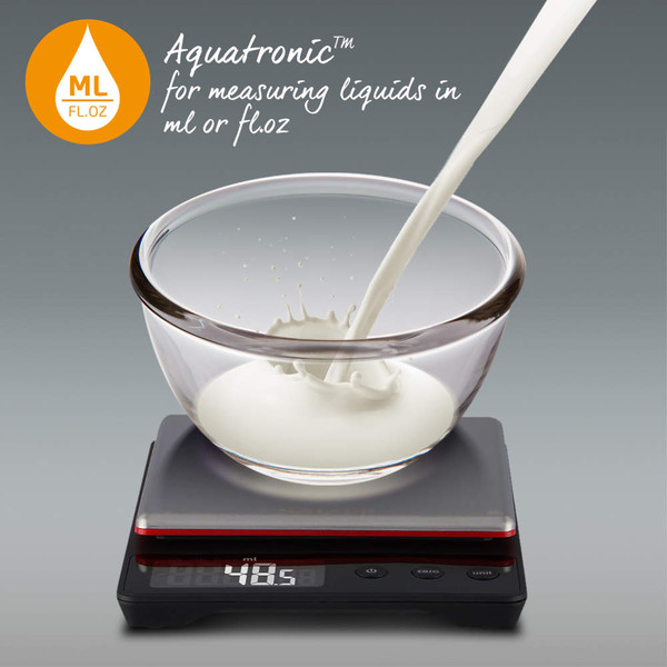 Glass bowl of milk being weighed on kitchen scale, showing Aquatronic liquid measurement feature.