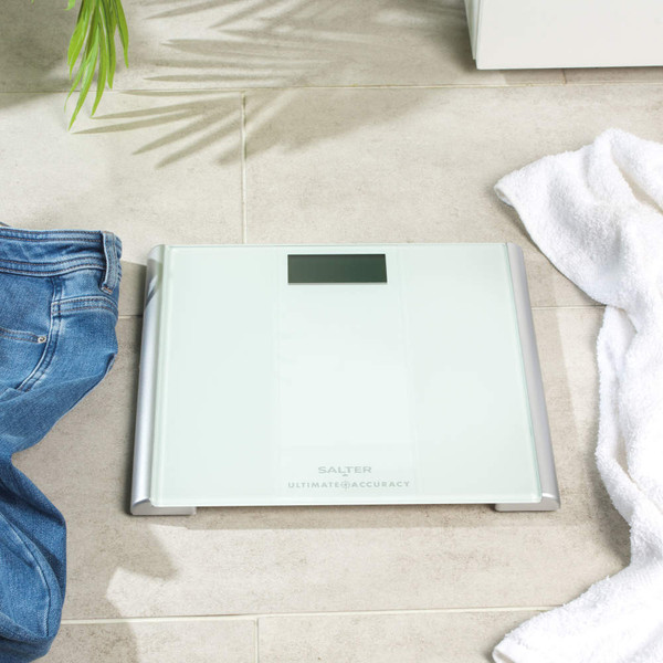 White digital bathroom scale showing close-up of kg LCD display, reading zero