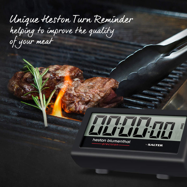 Digital meat timer by Heston Blumenthal next to steak on BBQ grill, grilling aid feature shown