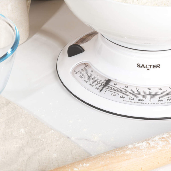 White Salter mechanical kitchen scale with bowl, shown in use with flour on worktop