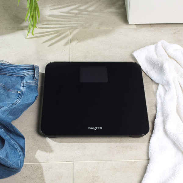 Black bathroom scale with Salter logo on tiled floor