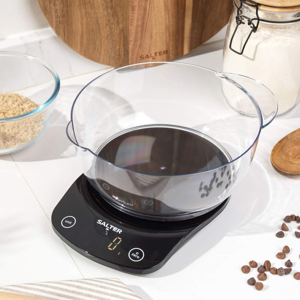 Black digital kitchen scale with large clear bowl on worktop, display shows zero