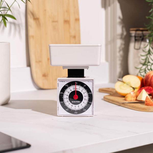 White mechanical kitchen scale with bowl on countertop