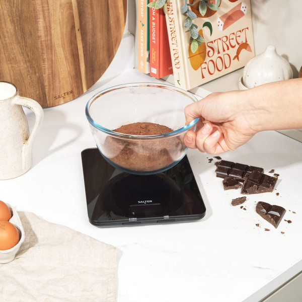 Black digital kitchen scale with red LED display showing zero grams