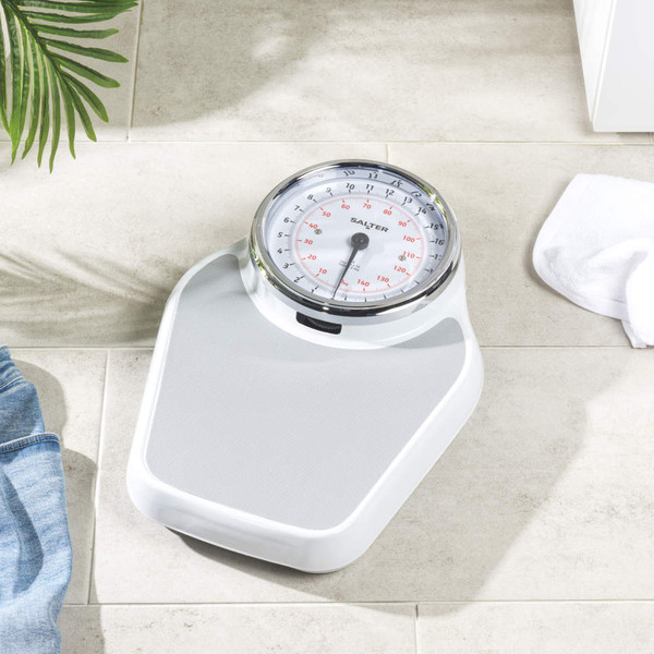 Person standing on bathroom scale in white towel