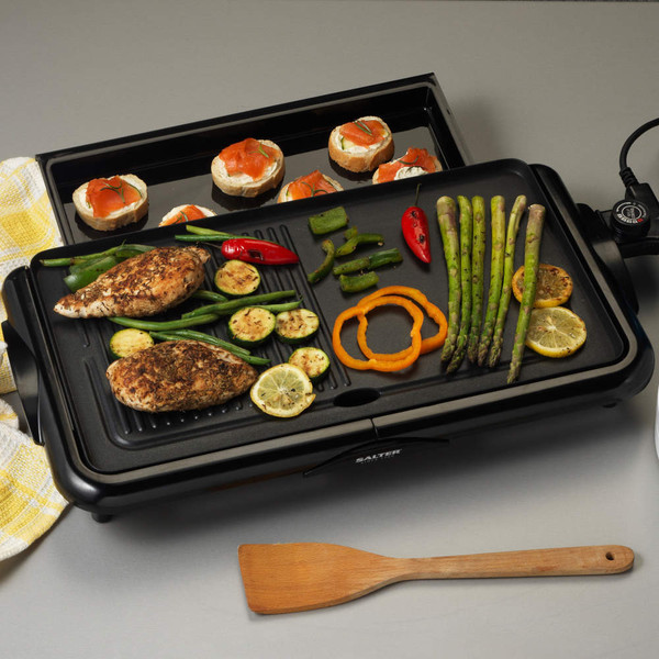 Electric grill with cooked chicken fillets, vegetables, and salmon canapés on tray