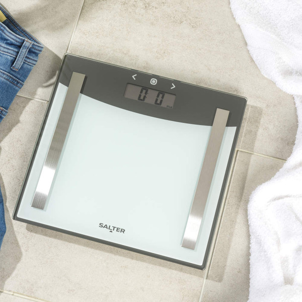 Salter glass bathroom scale with stainless steel accents on tiled floor