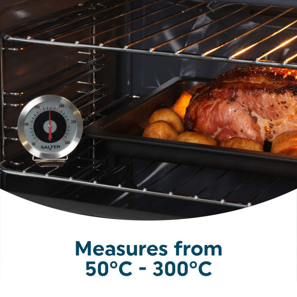 Oven thermometer and roast joint in tray, showing temperature for accurate cooking.