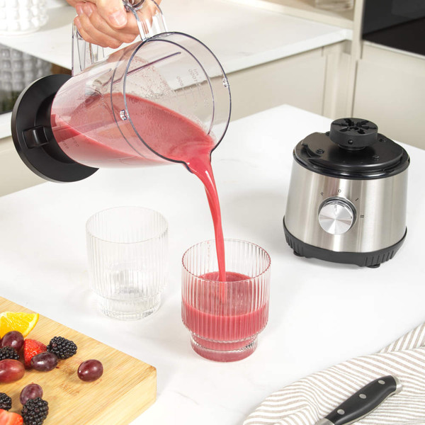 Stainless steel blender and juicer set with fruit, nuts, and juice containers.