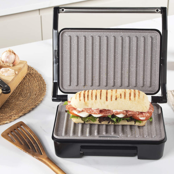 Grey electric grill with open non-stick plates and removable drip tray