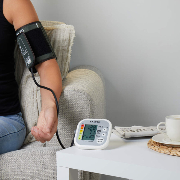 Salter automatic blood pressure monitor in use on arm, LCD display showing results