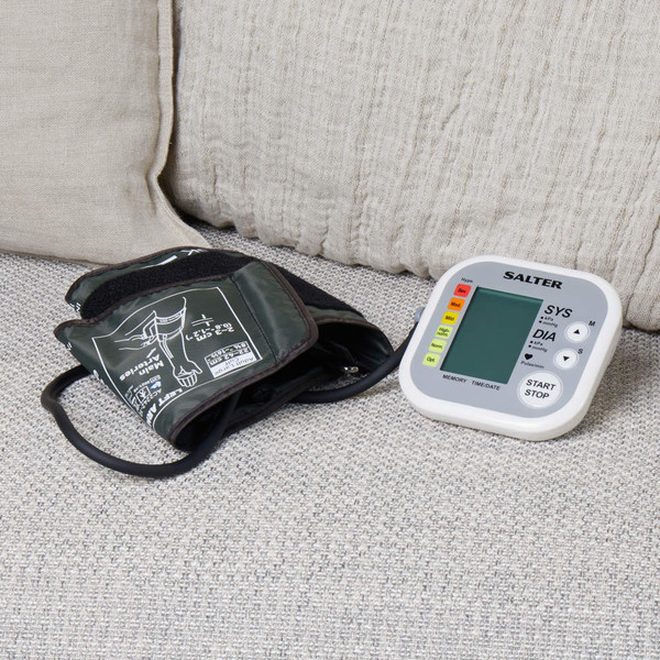 Automatic blood pressure monitor with arm cuff on a sofa