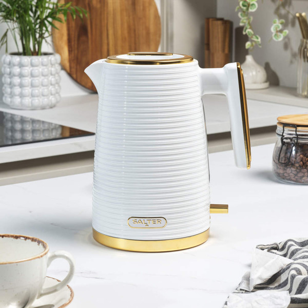 White ribbed electric kettle with gold accents on kitchen countertop