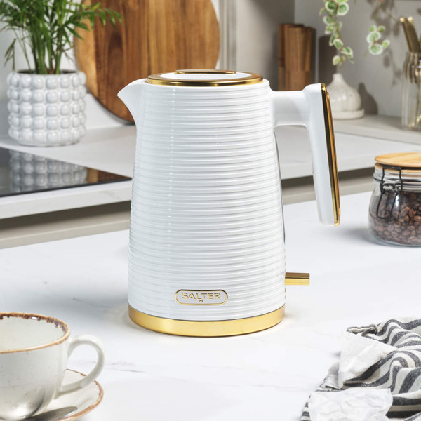 White ribbed electric kettle with gold accents on kitchen countertop