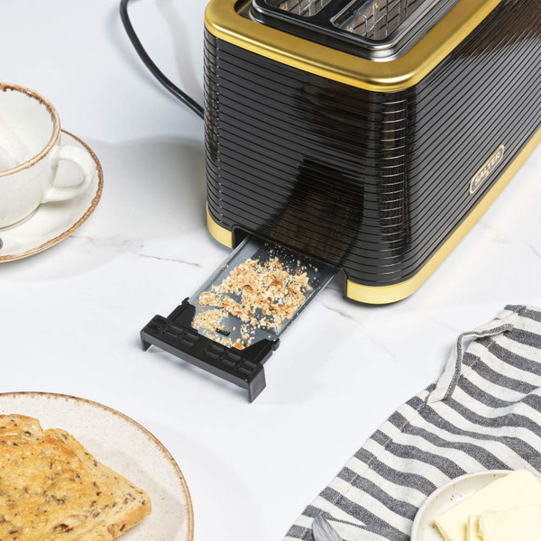 Black and gold toaster with crumb tray partly pulled out, showing easy cleaning feature
