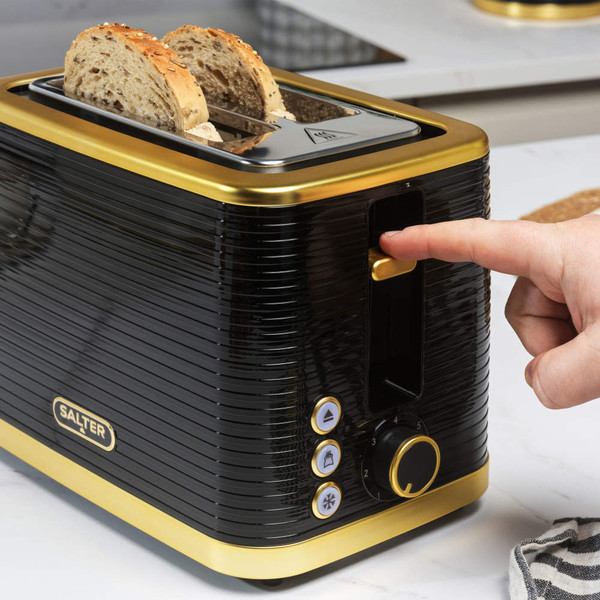 Black and gold two-slice toaster with seeded bread, button controls and hand pressing lever