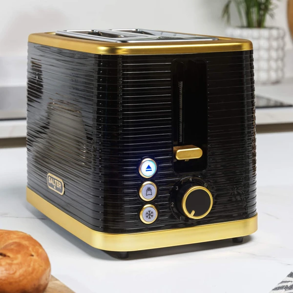 Black and gold two-slice toaster with seeded bread, button controls and hand pressing lever