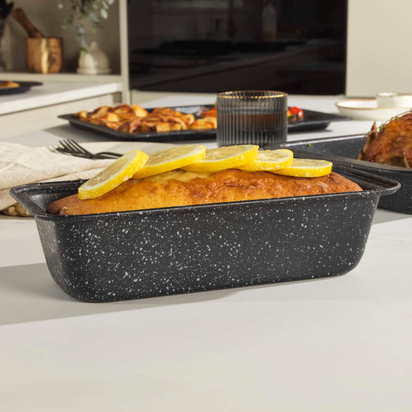 Grey speckled loaf tin with baked lemon drizzle cake, product in kitchen setting