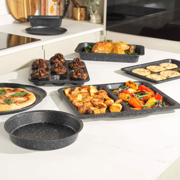 Set of grey speckled non-stick baking trays and tins displayed with baked goods