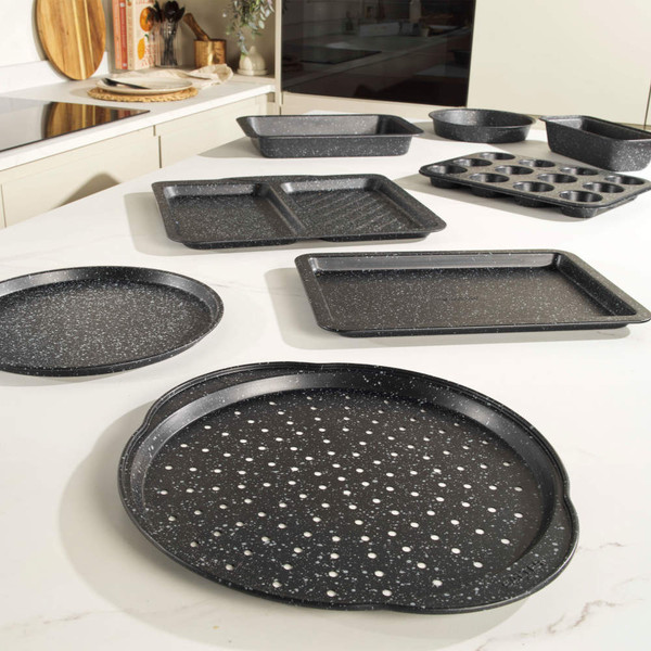 Set of black speckled non-stick bakeware trays and tins on kitchen worktop