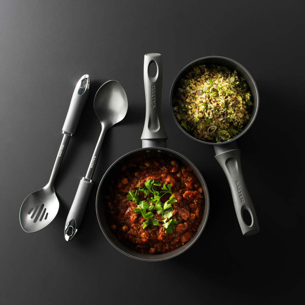 Set of two non-stick Salter saucepans with serving spoons, filled with cooked food, on black background