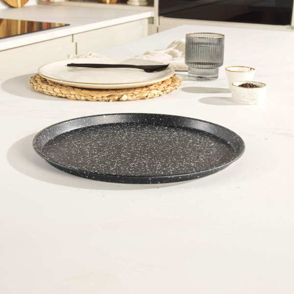Black speckled pizza tray on a kitchen worktop