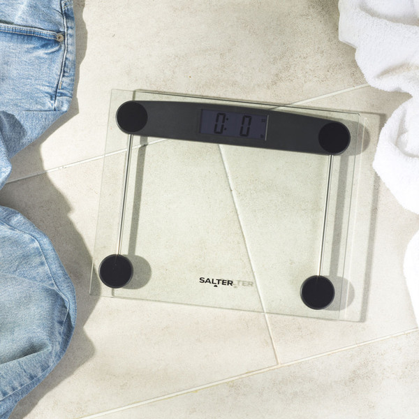 Digital glass bathroom scale with black accents on light tiled floor