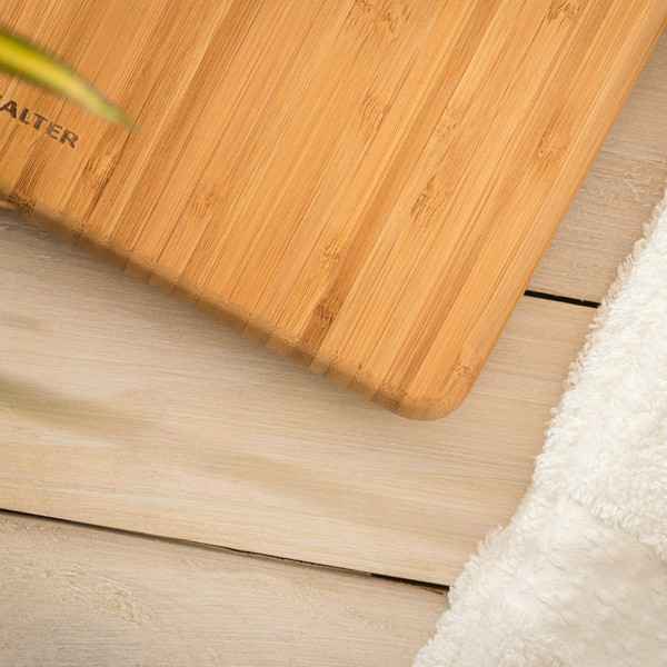 Salter bamboo bathroom scale on light wood floor beside white towel.