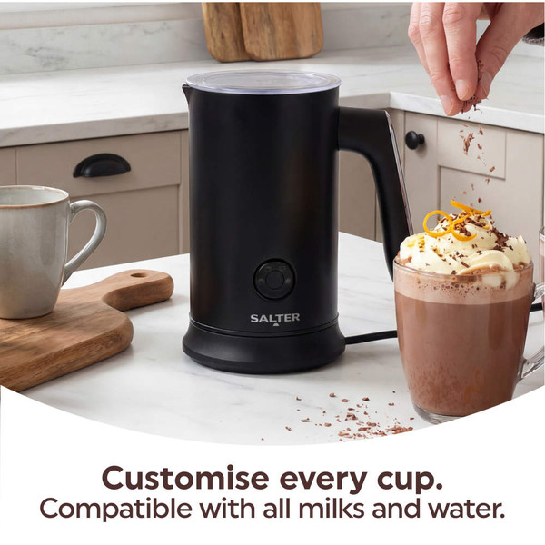 Black Salter milk frother in kitchen, next to hot chocolate with cream.