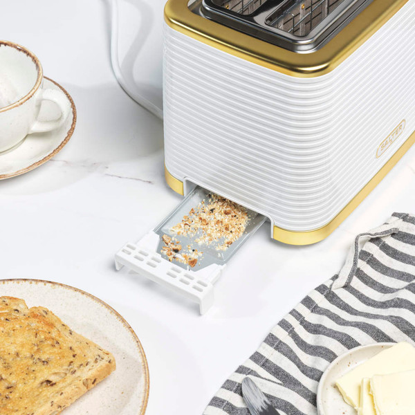 White and gold toaster in use, featuring two slices of seeded bread in kitchen setting