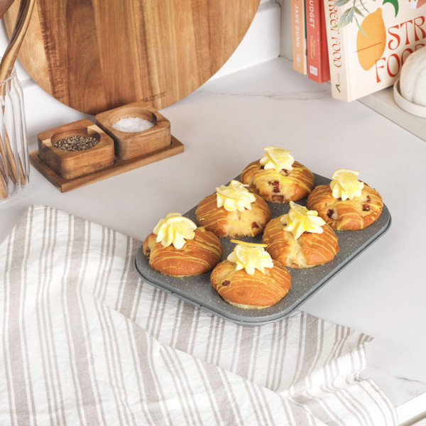 Grey non-stick 6-cup muffin tray, shown empty, angled front view