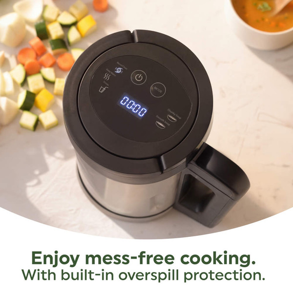 Stainless steel soup maker with black lid stored in a white kitchen cupboard