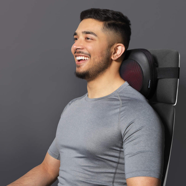 Deep kneading shiatsu massage pillow with soothing heat, shown in use on a sofa
