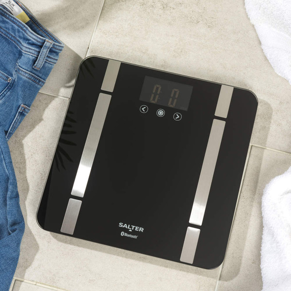 Black Salter Bluetooth bathroom scale with silver accents on tiled floor