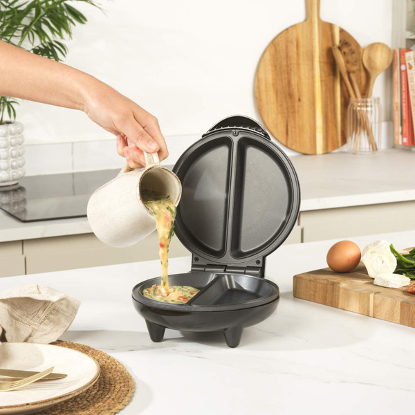 Black non-stick breakfast maker, open, showing two deep compartments