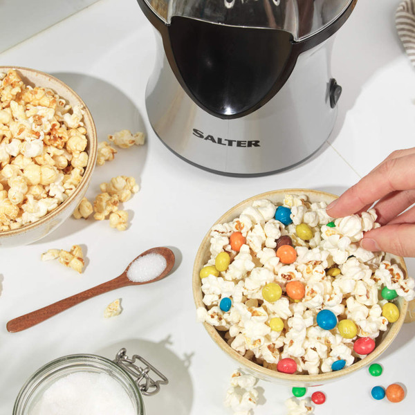 Hot air popcorn maker with kernels and popped corn in clear chamber