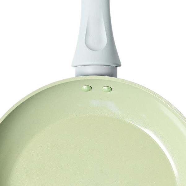 Light green non-stick frying pan, close-up of interior and handle.