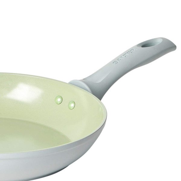 Grey non-stick frying pan with light ceramic interior, angled to show handle.