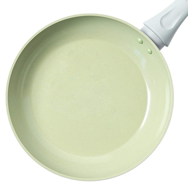 Cream ceramic frying pan, overhead view, with white handle