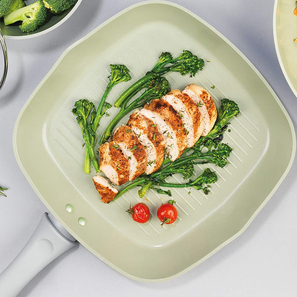 Square grill pan with sliced cooked chicken breast, broccoli and cherry tomatoes.