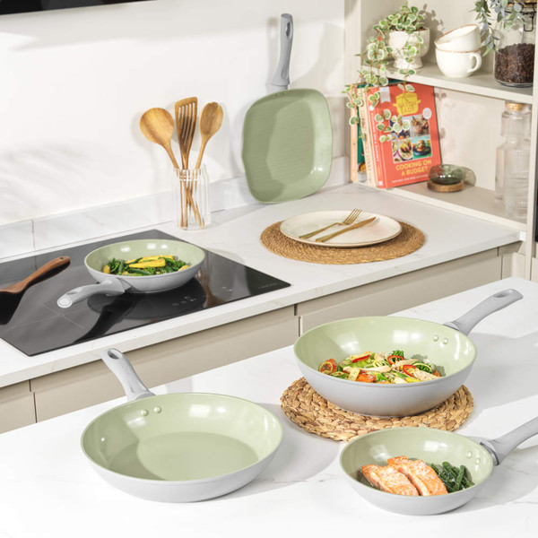 Green ceramic frying pan with cooked chicken breasts, shown from above