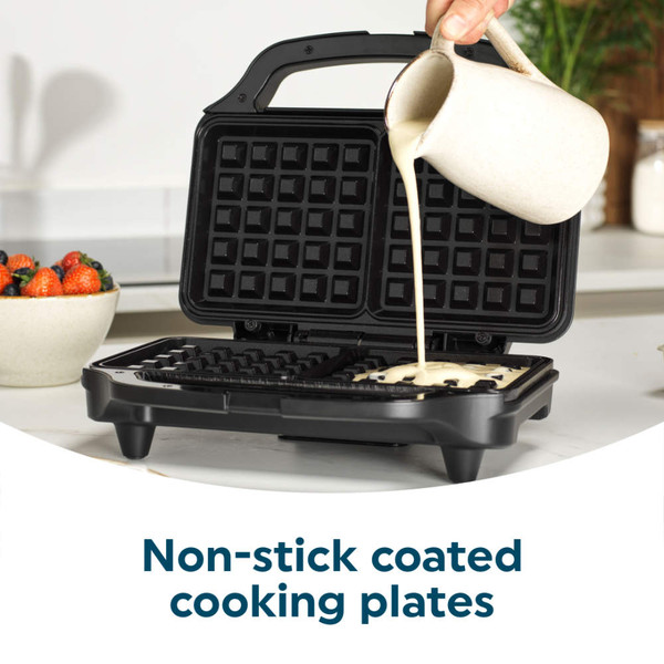 Waffle maker with non-stick cooking plates and batter being poured in