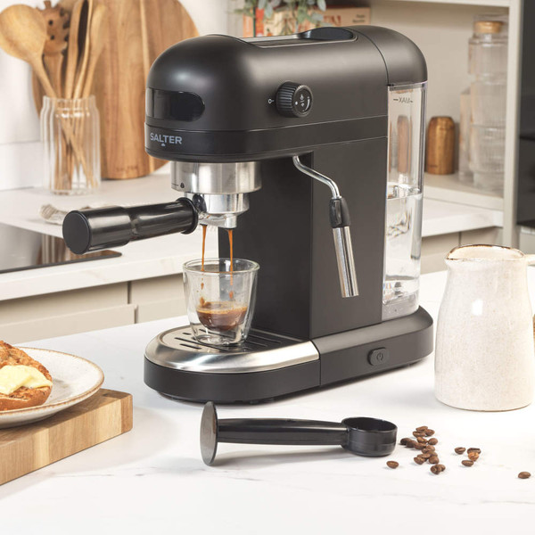 Black Salter espresso coffee machine brewing into glass cup on kitchen counter