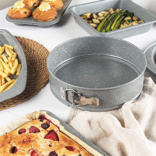 Grey non-stick cake tin with latch being placed in kitchen drawer