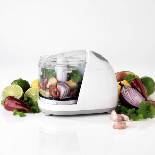 White electric mini chopper with mixed vegetables inside, shown on a counter