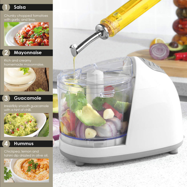 Food processor on kitchen counter with oil being poured in, ready to make salsa, mayonnaise, guacamole or hummus