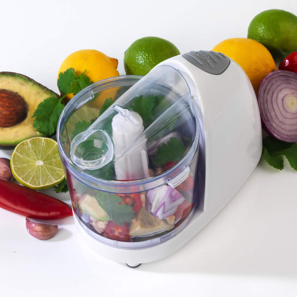 White electric mini chopper with mixed vegetables inside, shown on a counter