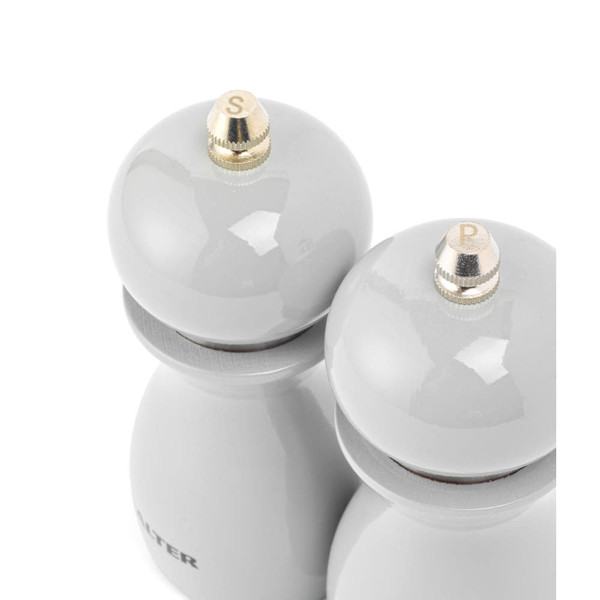 Grey salt and pepper mills set with gold tops, shown from above.