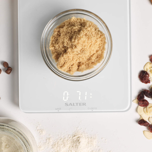 Glass bowl of brown sugar on white Salter digital kitchen scale, display shows 7.1 oz.
