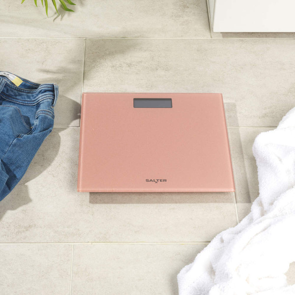 Rose gold digital bathroom scale in cabinet with sponge and toilet rolls